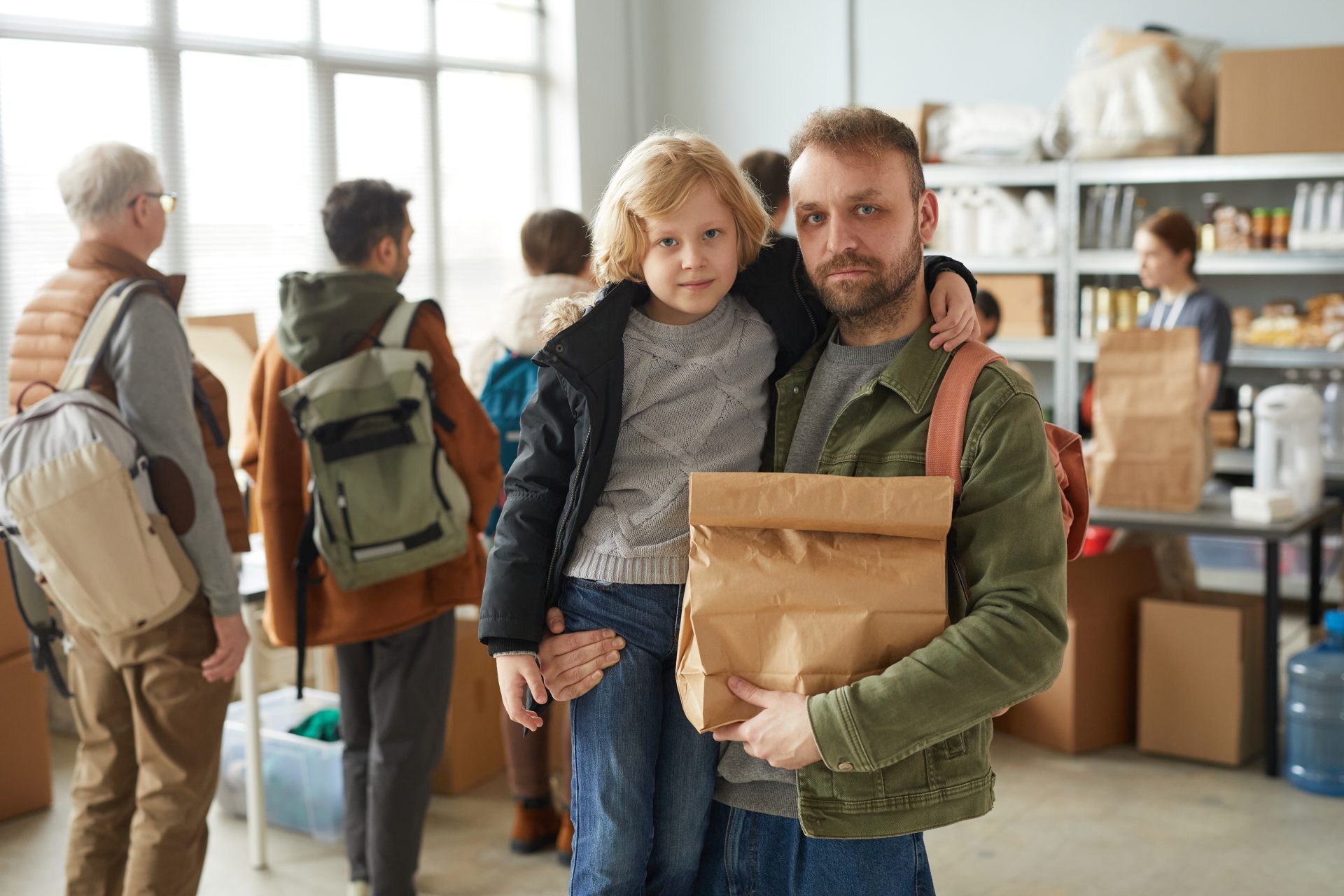 A father and child receiving food at a humanitarian relief distribution center